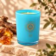 Mahonie Amber Candle, three-quarter view on pale natural stone.