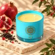 Mahonie Black Tea & Pomegranate Candle, elevated view on pale natural stone.