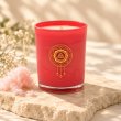 Mahonie Cotton Candy Candle, red glass, on pale natural stone.