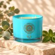 Mahonie Eucalyptus & Mint Candle, turquoise glass, on pale natural stone.