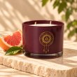 Mahonie Grape Fruit Candle, three-quarter view on pale natural stone.