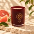 Mahonie Grape Fruit Candle, three-quarter view on pale natural stone.
