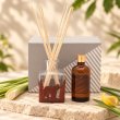 Mahonie L'étoile Reed Diffuser Set - Lemongrass & Citrus wood, original bottle, reeds, refill and box shown on source, on pale natural stone.
