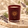 Mahonie Lavender Candle, burgundy glass, on pale natural stone.