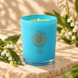 Mahonie Lily of the Valley Candle, turquoise glass, on pale natural stone.