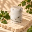 Mahonie Métallique : Exquisite Patchouli Candle, elevated view on pale natural stone.