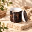Mahonie Métallique : Midnight Musk Candle, three-quarter view on pale natural stone.