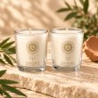 Mahonie Shot Glass Pair : Gilli Mitti Candle, two clear shot glasses, on pale natural stone.