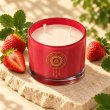 Mahonie Strawberry Candle, elevated view on pale natural stone.