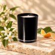 Mahonie Yan Single Wicked Candle - Nerolie, black glass, on pale natural stone.